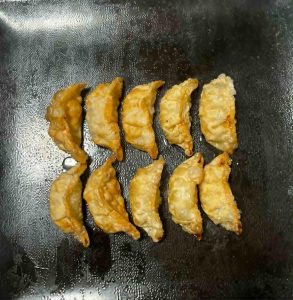 Portion de 10 raviolis japonais Gyoza au poulet, grillés à la poêle et fondants.