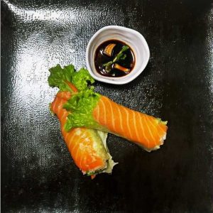 Deux rouleaux de printemps frais au saumon, légumes croquants et herbes aromatiques.